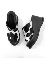 Sandalias con plataforma de cuero sintético color negro y estampado animal print de vaca en la tira delantera.