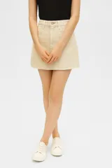 Minifalda de jean color beige con terminación desflecada.