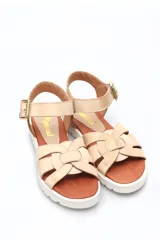 Sandalia de cuero con tiras cruzadas y hebilla lateral, color beige.