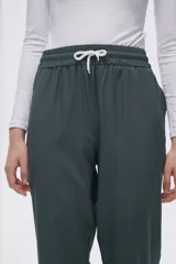 Pantalón de jogging color celeste con cintura elástica ajustable con cordón y puños elásticos. Presenta tres tiras verticales blancas en la parte inferior de la pierna.