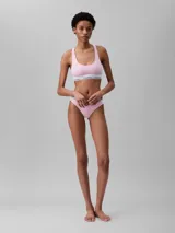 Conjunto Calvin Klein de top deportivo y tanga color rosa claro, con banda elástica blanca con logo de la marca.