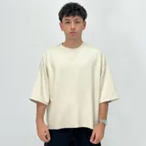 Remera color crema de corte boxy, manga 3/4 y estampado con el número 1999.