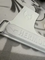 Calleras de gimnasia blancas con logo de la marca y correa de ajuste en la muñeca.