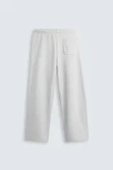 Pantalón jogger wide fit negro confeccionado en tejido de algodón con interior rizo. Pernera ancha, cintura elástica ajustable con cordón interior, bolsillos laterales y bolsillo trasero de plastrón.