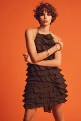 Vestido corto marrón con cuello halter y falda con volantes.