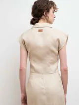 Camisa blanca de lino con cuello clásico, abotonada al frente y mangas cortas.
