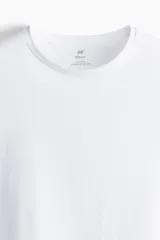 Remera blanca de corte ajustado, con cuello redondo ribeteado y bajo recto. Confeccionada con tejido funcional COOLMAX®, una fibra exclusiva de poliéster de secado rápido que elimina la humedad y regula la temperatura corporal proporcionando un ajuste cómodo y suave.