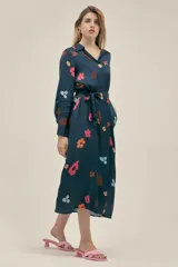 Vestido largo camisero azul marino con estampado floral multicolor, botones nacarados, bolsillos laterales, aberturas laterales y cinturón de lazo.