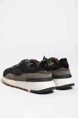 Zapatillas deportivas color beige con detalles en marrón y amarillo.