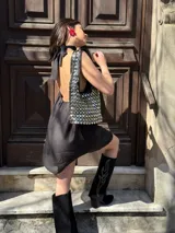 Vestido corto negro con cuello halter y corte holgado.