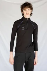 Remera térmica negra de manga larga, confeccionada en jersey de algodón grueso con vivos azules en contraste y logo bordado. Presenta cierre YKK en el cuello.