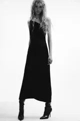 Vestido midi negro de satén, con escote asimétrico y tirante fino.