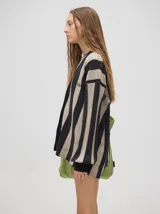 Cardigan a rayas horizontales en tonos beige y negro, de corte holgado y abierto, con botones metálicos y logo MUTMA bordado en el frente.