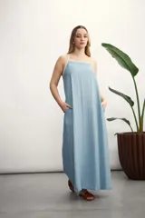 Vestido largo celeste de tirantes finos con ribete blanco, corte recto y bolsillos laterales.