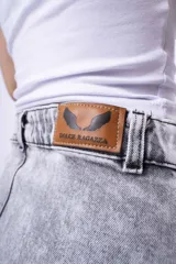 Minifalda de jean gris con efecto lavado, tiro alto, corte ajustado y volados en el ruedo.