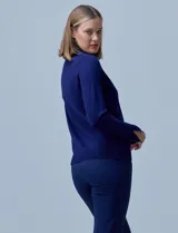 Polera de punto fino marca Nienty, color blanco, con cuello alto volcado y mangas largas con detalle de tajo en los puños.