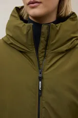 Campera acolchada larga, color blanco, con capucha grande y cierre frontal de cremallera negra. Presenta bolsillos laterales con cremallera negra.