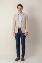 Saco de lino color beige, corte slim fit, con solapa de muesca, cierre de dos botones, bolsillo en el pecho y dos bolsillos delanteros con solapa. Medio forro.
