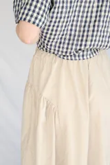 Falda midi color beige de microfibra con cintura elastizada y frunces laterales.