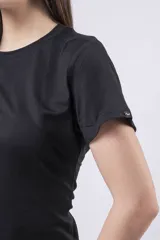 Remera ajustada de manga corta, color amarillo vibrante, con cuello redondo. Presenta un pequeño detalle de etiqueta negra en la manga derecha.