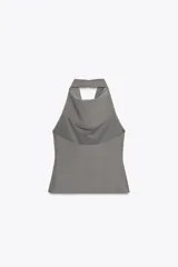 Top color beige de cuello halter con botones y espalda descubierta. Cierre lateral con cremallera oculta.
