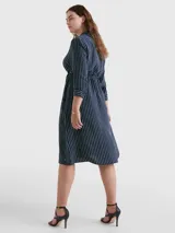 Vestido camisero midi azul marino con rayas verticales blancas, cuello camisero, cierre frontal con botones, mangas largas con puños abotonados y cinturón de lazo a juego.