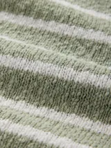 Sweater de punto color verde claro con rayas horizontales blancas, de corte holgado y cuello redondo.