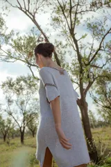 Minivestido tejido en lurex plateado, con escote en V y mangas cortas. Presenta detalle de bordado en el escote y mangas.