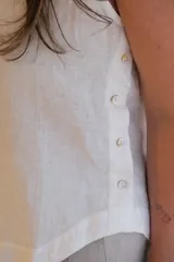 Musculosa blanca de lino con botones dorados en el lateral.