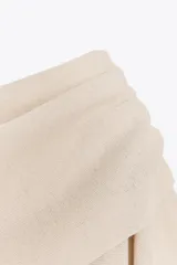 Top color crema de tejido de punto, con cuello asimétrico y mangas anchas.