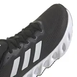 Championes Adidas Switch Run, color negro con detalles plateados y suela blanca. Presentan las tres tiras características de la marca en los laterales.