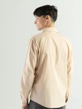 Camisa de manga larga color verde oliva, confeccionada en algodón. Tiene corte clásico, bolsillo en el lado izquierdo del pecho y cierre con botones.