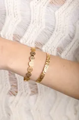 Brazalete dorado con diseño de monedas y brazalete dorado con textura.