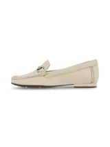 Mocasín de cuero color crema con detalle de hebilla metálica plateada.
