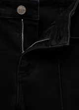 Pantalón capri de denim negro, tiro medio, corte skinny, con cierre de cremallera y botón, trabillas, bolsillos delanteros y traseros, y costuras decorativas.