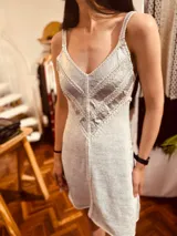 Vestido corto de fiesta color gris, con breteles finos y escote en V. Presenta un diseño de lurex en la parte superior y falda de tejido de punto.