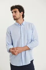 Camisa azul marino de lino y algodón, con cuello abotonado, manga larga con puños enrollados, bolsillo de parche en el pecho y cierre frontal con botones.
