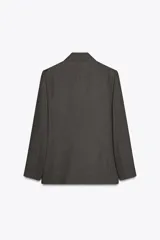 Blazer gris con diseño de líneas verticales, cuello solapa, manga larga con hombreras, bolsillos delanteros de vivo y cierre frontal cruzado con botones.