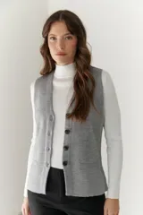 Chaleco gris de tejido de punto con cuello en V, cierre frontal con botones y bolsillos delanteros.