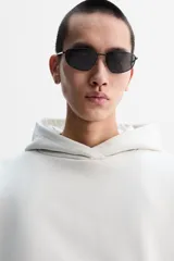 Sudadera color crudo, estilo hoodie, corte boxy, con capucha, manga larga, bolsillo tipo canguro y terminaciones en rib.