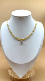 Gargantilla de cristalitos facetados color amarillo con dije de punto de luz blanco.