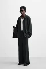 Pantalón negro de corte amplio con cintura elástica ajustable con cordón, bolsillos delanteros y detalle de bolsillo trasero de vivo.