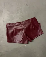 Shorts de efecto cuero color bordó con tiro alto y múltiples correas ajustables con hebillas y ojales metálicos plateados.