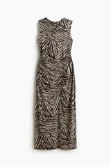 Vestido tobillero ajustado sin mangas, con escote redondo y estampado de cebra en tonos beige y negro. Presenta costura fruncida en el frente para crear un efecto drapeado.