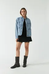 Campera de jean celeste con bolsillos tipo cartera y cierre frontal con botones.