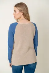 Sweater de lana azul con mangas ranglan color beige.