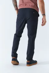 Pantalón chino color beige, de corte slim, con bolsillos laterales y traseros. Se ajusta a la cintura con cinturón de cuero marrón.