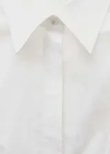 Camisa blanca de algodón con diseño entallado, cuello camisero, mangas largas con detalle metálico y cierre frontal de botones oculto.