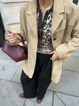 Blazer color beige de gamuza con solapas de muesca, cierre con botones y bolsillos laterales.