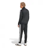Conjunto deportivo Adidas negro de tricot, compuesto por campera con cierre y pantalón. La campera tiene cuello alto, cierre frontal, bolsillos laterales y las tres franjas blancas características en las mangas. El pantalón tiene cintura elástica con cordón ajustable y las tres franjas blancas en los laterales.